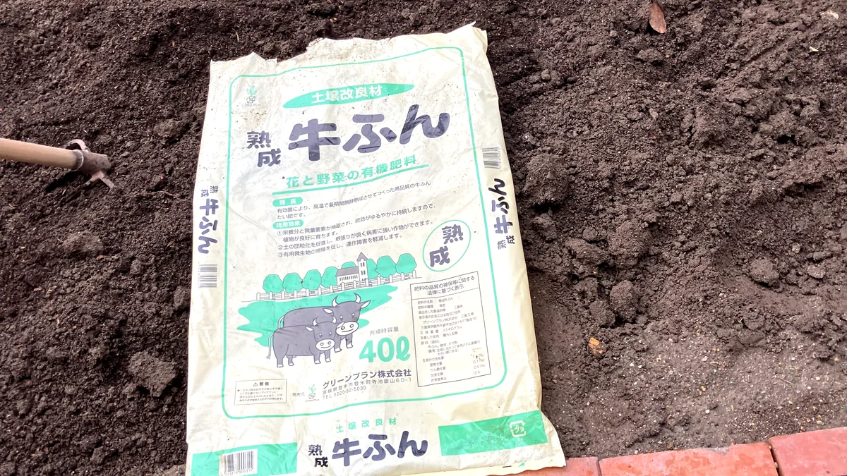 土づくりで使った熟成牛ふんの袋を耕した花壇に置いた実物写真